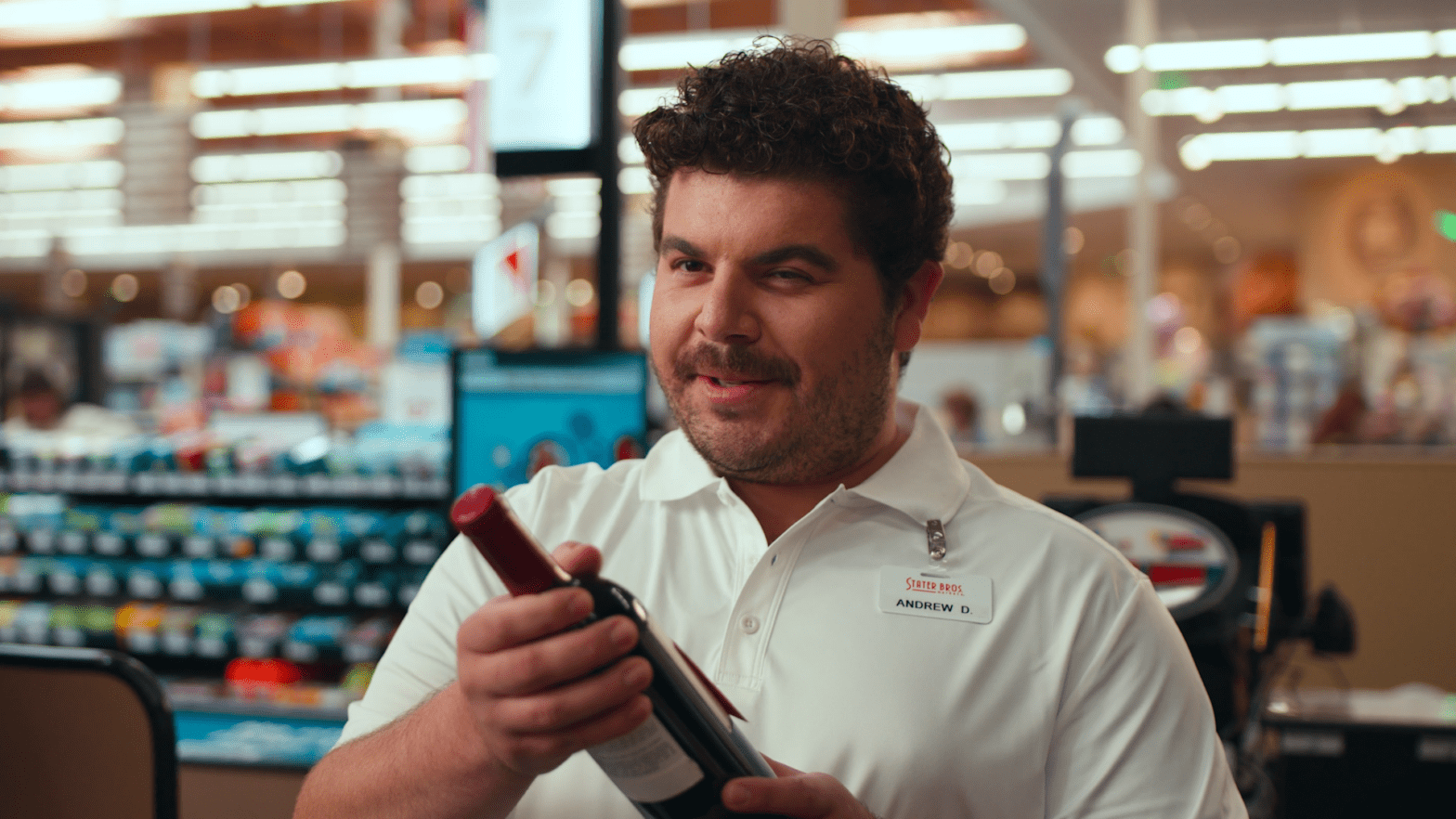 Store employee examining a bottle of sauce with a slight smile on his face, perfect for a date night grocery shopping list at Stater Bros.
