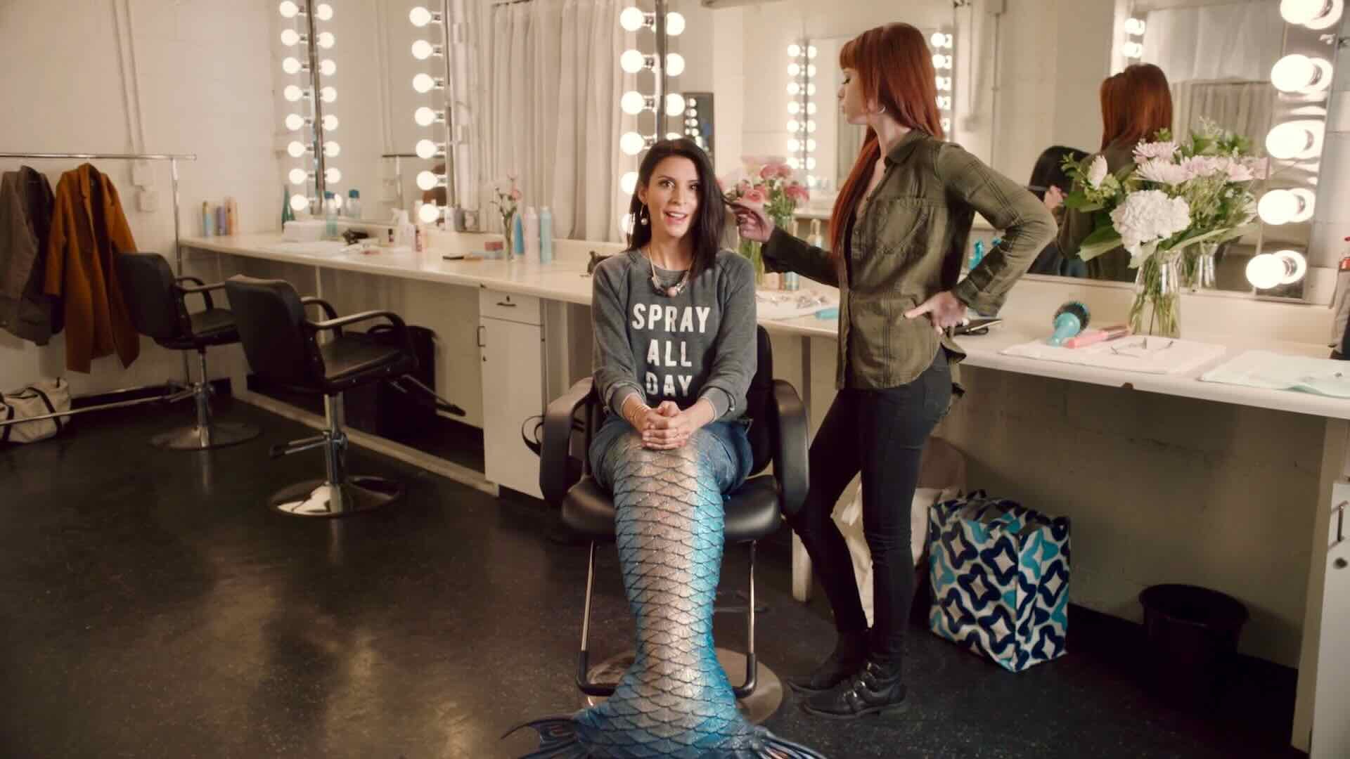 A mermaid sitting in a makeup chair