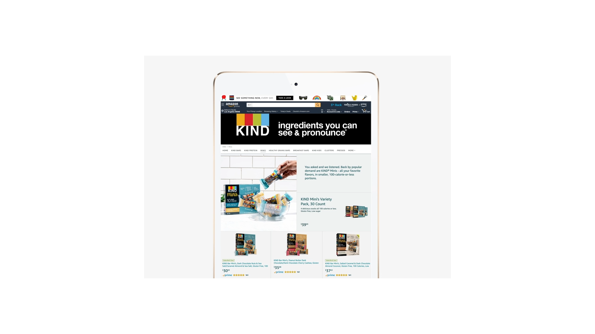 A tablet screen displays a product page for KIND snacks, showcasing various products, customer reviews, and an image of a hand grabbing a bar from a box. The header reads "ingredients you can see & pronounce," highlighting the health-savvy convenience of these go-to snacks.