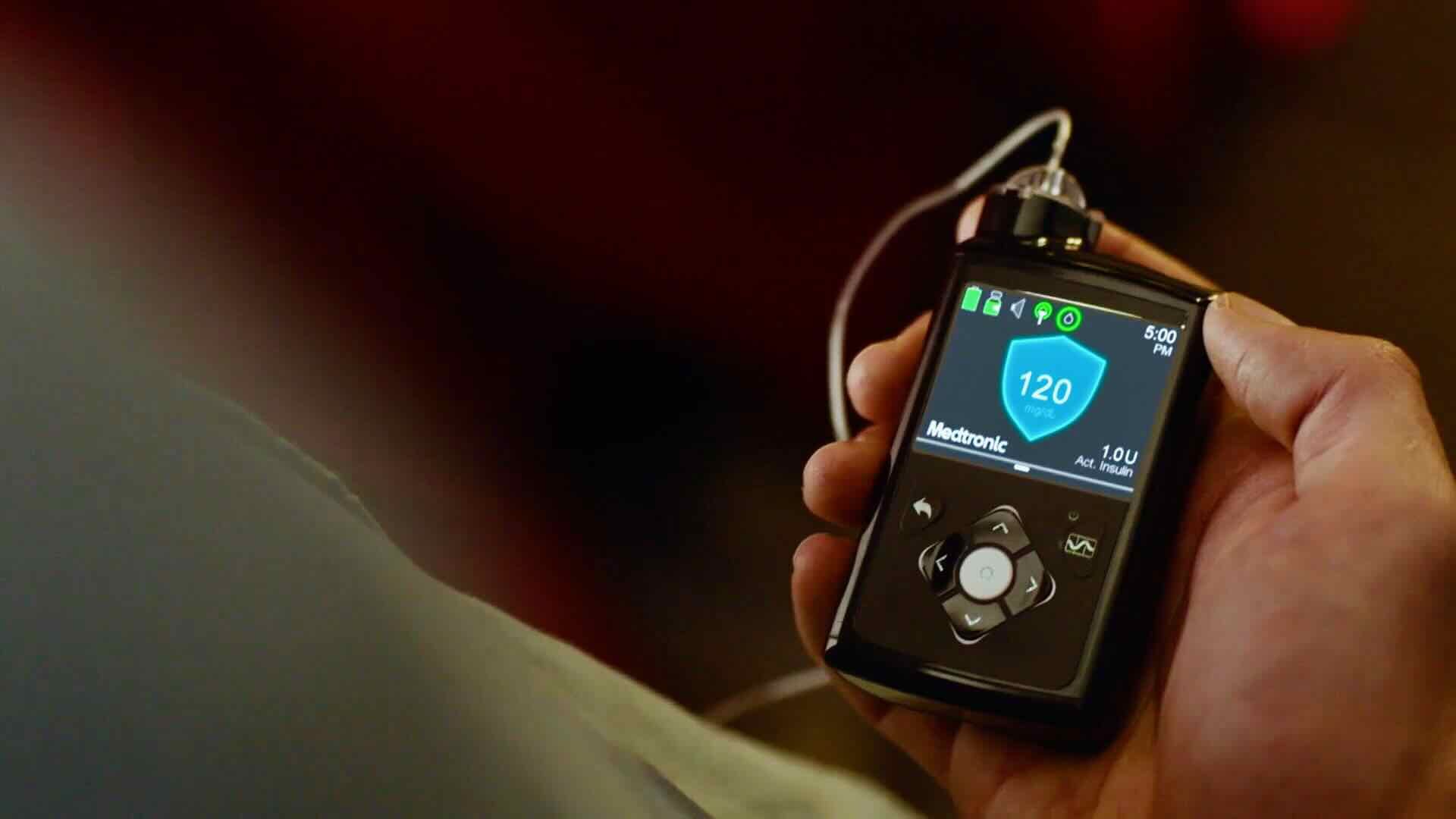A person holds a glucometer displaying a blood sugar level of 120 mg/dL at 5:09 PM, highlighting the effectiveness of this reliable medical device for B2C consumers.